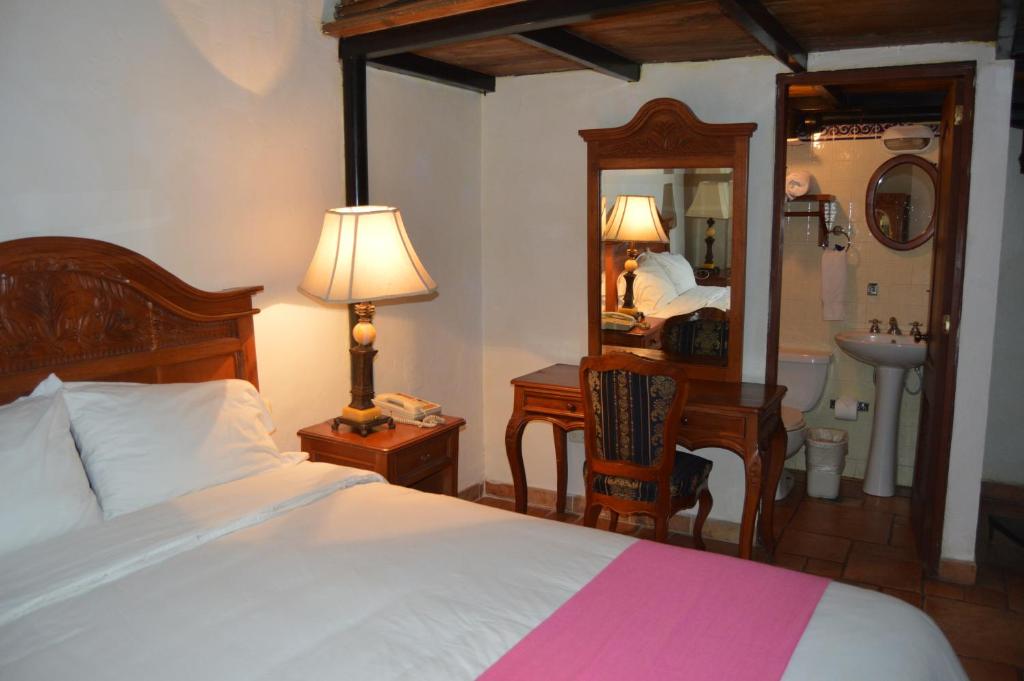 Guest room with bed and traditional furniture at Hotel Meson del Mar